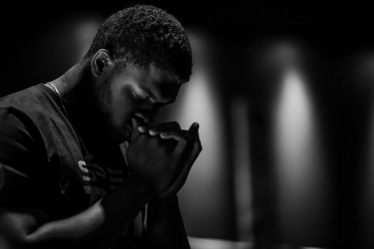 black and white photo of man praying