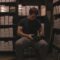 man sitting surround by files on shelves