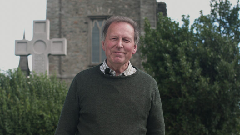 The Very Rev John Mann in front of a church