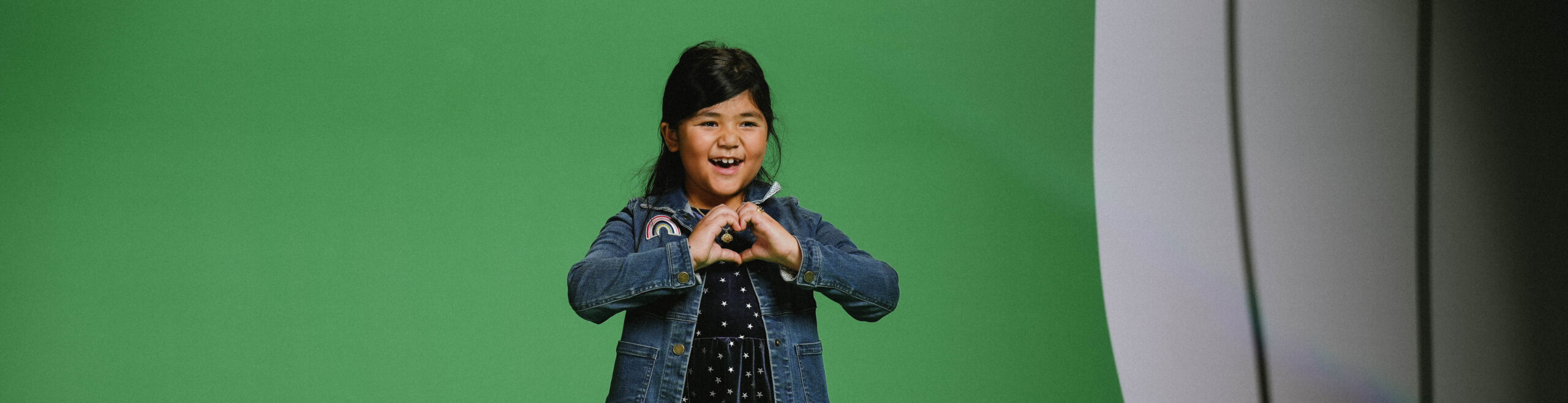 Little girl making a love heart with her hands