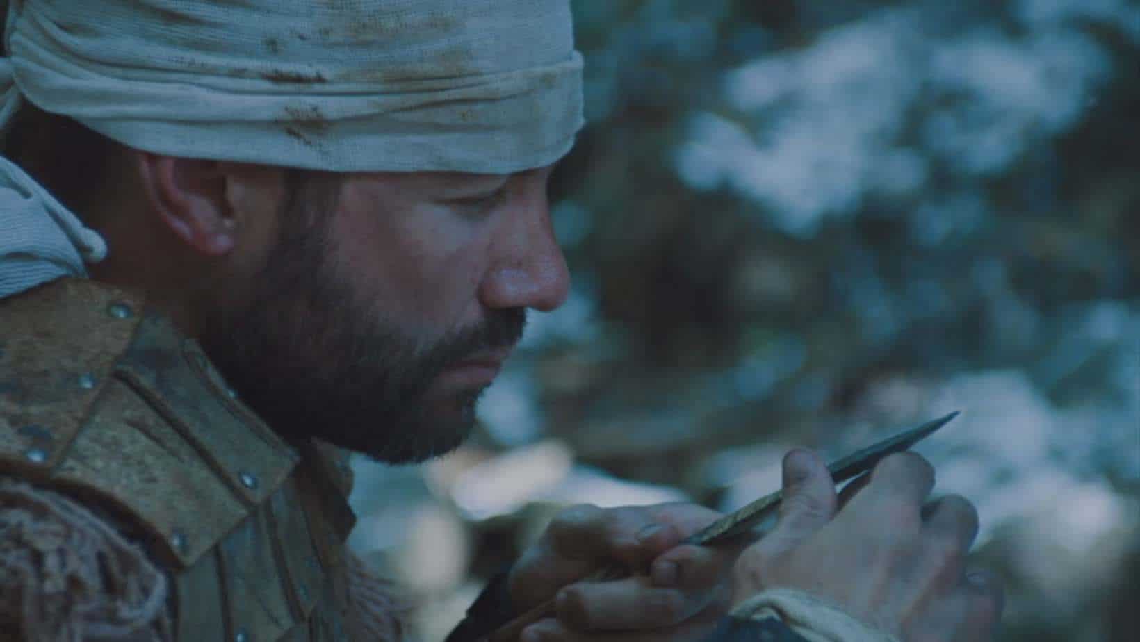 Military man sharpening at his weapon