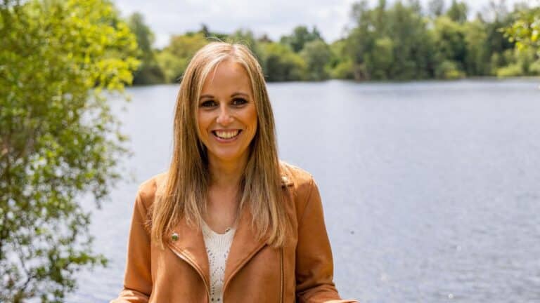 Lady smiling in front of a lake