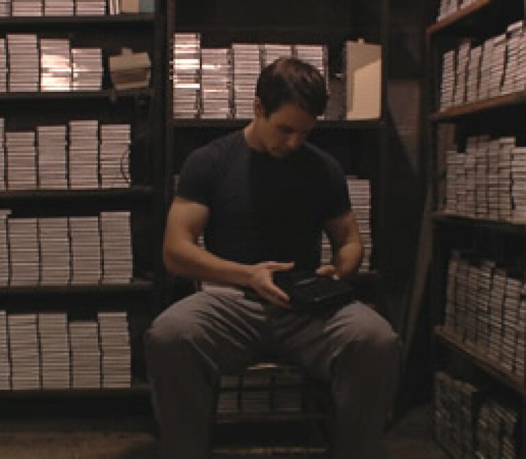 man sitting surround by files on shelves