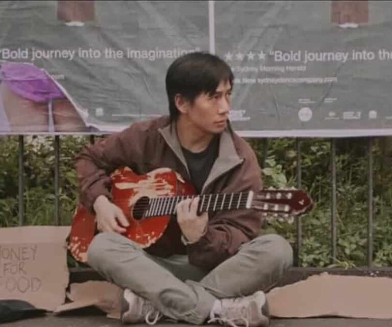 man busking with a guitar